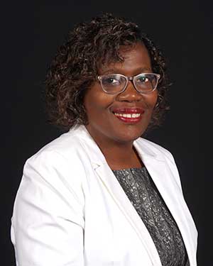 Headshot of Dr. Rolanda Johnson, wearing a white jacket and print blouse