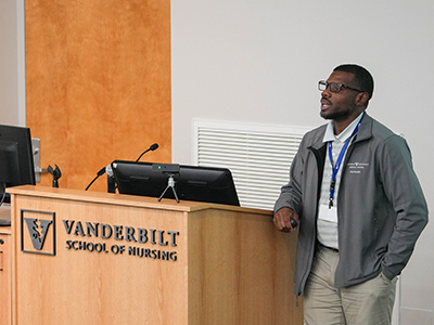 Man stands at a podium presenting at Vanderbilt School of Nursing