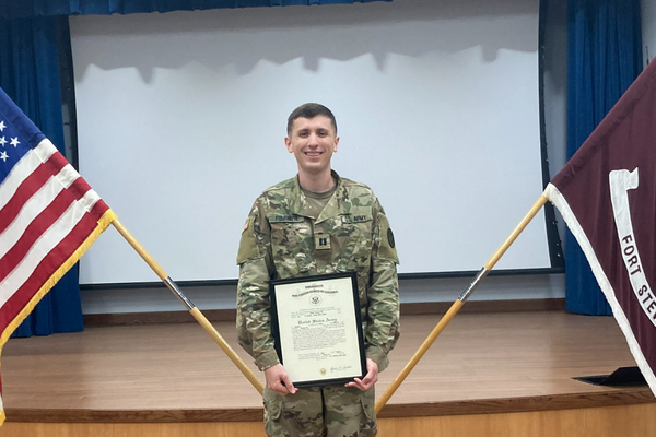 person in camo, holds a certificate