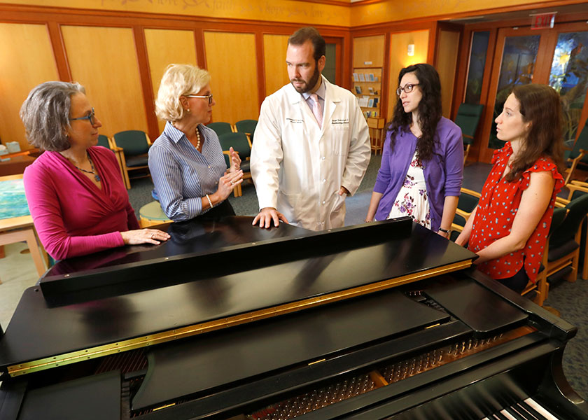 Vanderbilt researchers gathered around piano