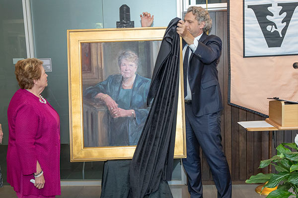 Linda Norman looks on as Chancellor Diermeier removes a drape from an oil portrait of her