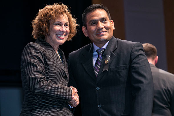 Dean Pam Jeffries shakes hands with male graduate