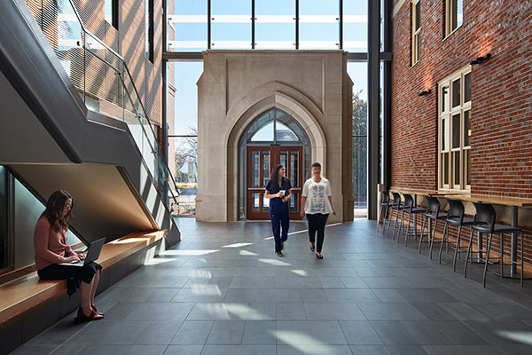 Two women walk toward the camera in the light filled atrium