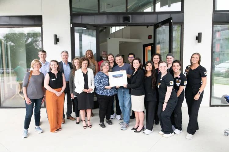 Group of people smiling holding a certificate