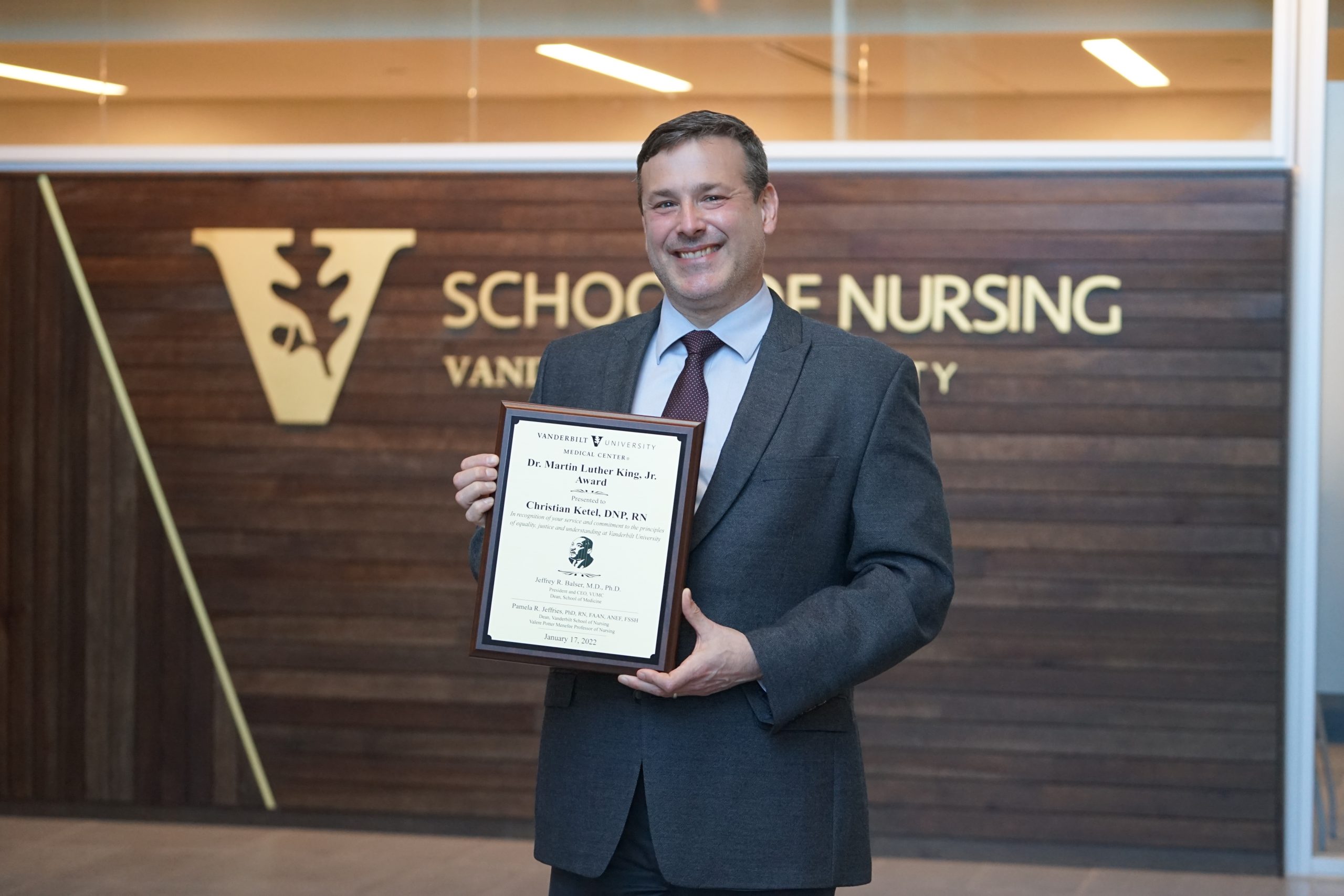 Person smiling holding award