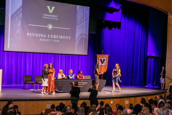 person walks across stage at pinning