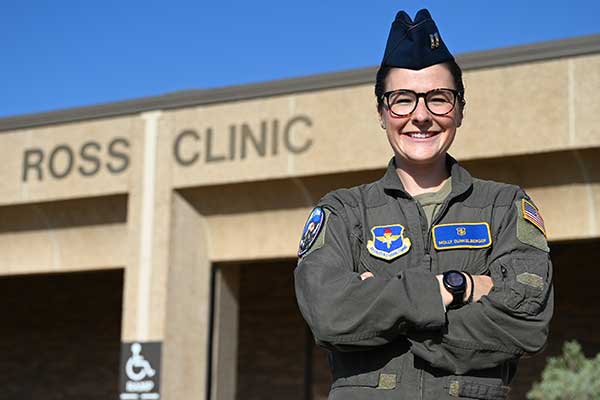 Female Air Force Captain poses in front of the Ross Clinic in Texas.