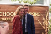 two people smiling in front of school of nursing sign