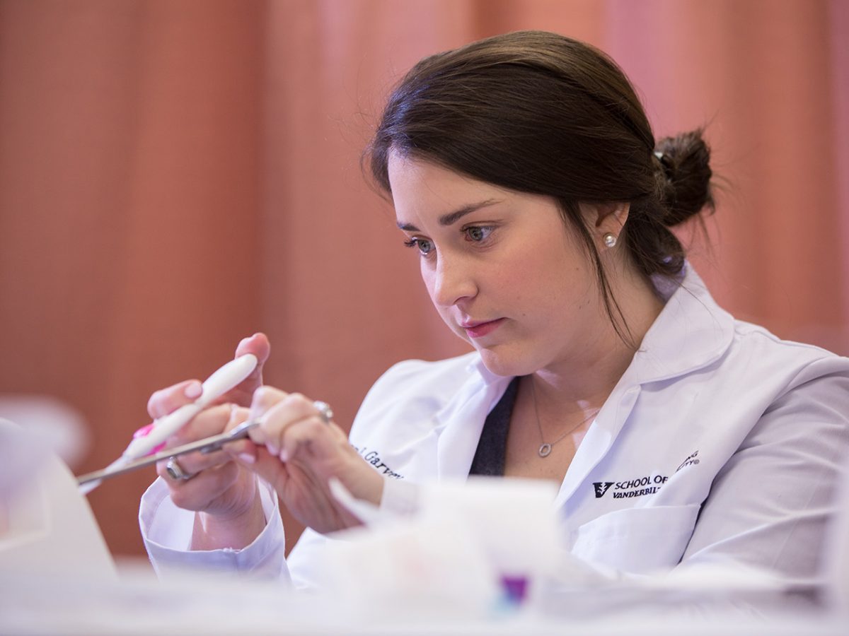 Women's health nurse practitioner student practices a pelvic exam