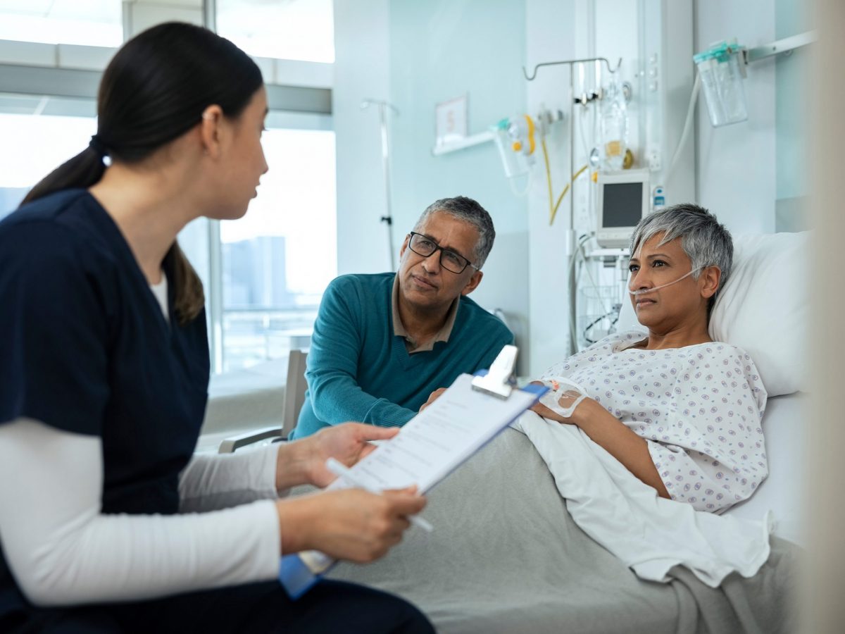 nurse speaks with patient and family member