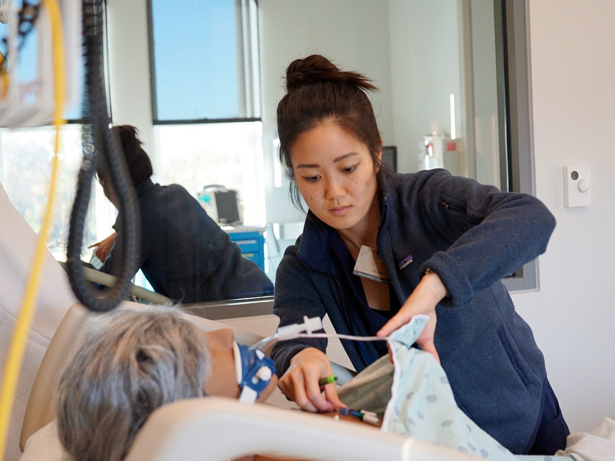 Female emergency nurse practitioner student adjusts a monitor on a 