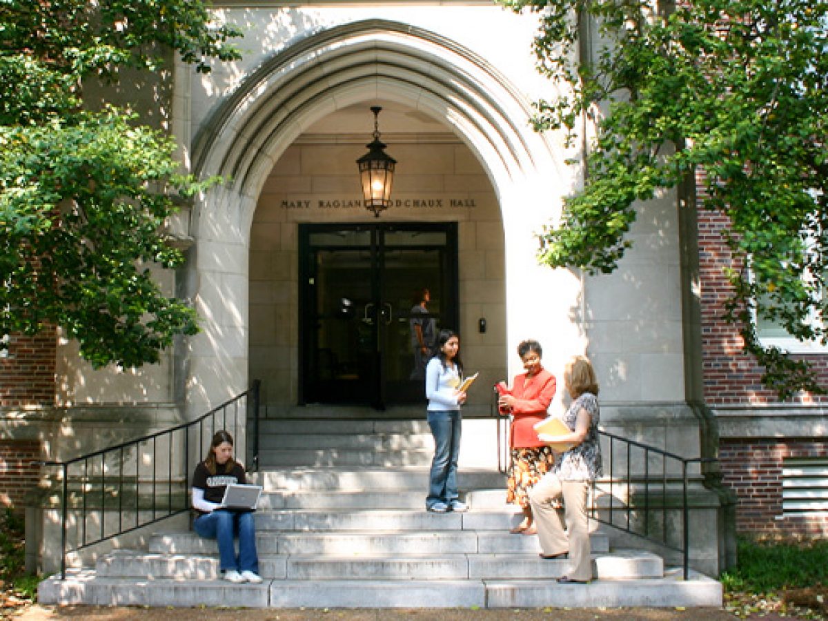 Students gathered outside a limestone and brick building