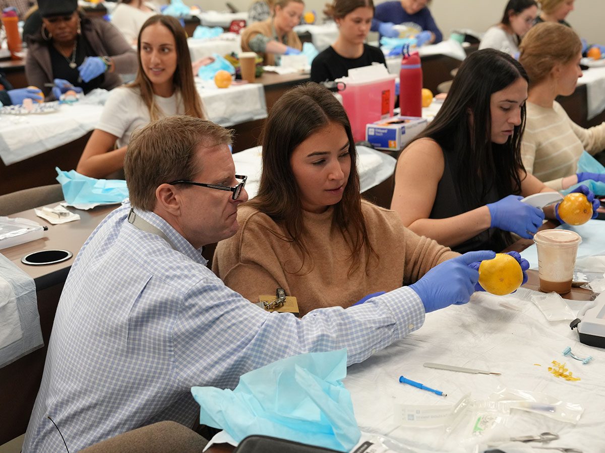 nursing instructor demonstrates how to suture